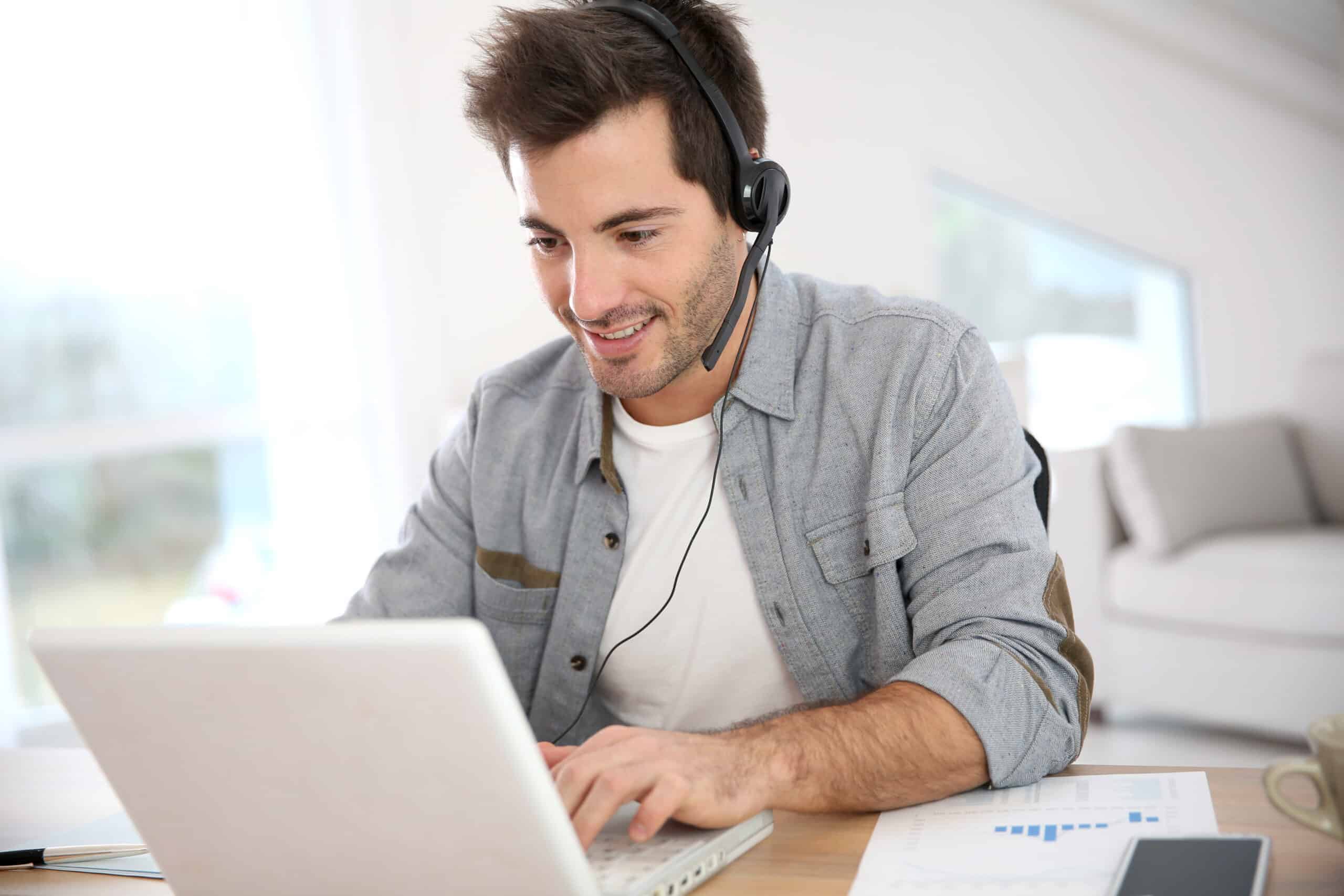 a man wearing a headset and using a laptop