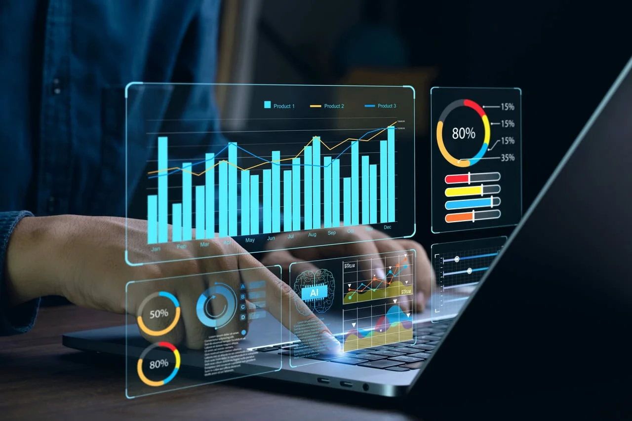 A person uses a laptop displaying virtual data visualizations, including bar and pie charts. The scene conveys advanced analytics and technology.