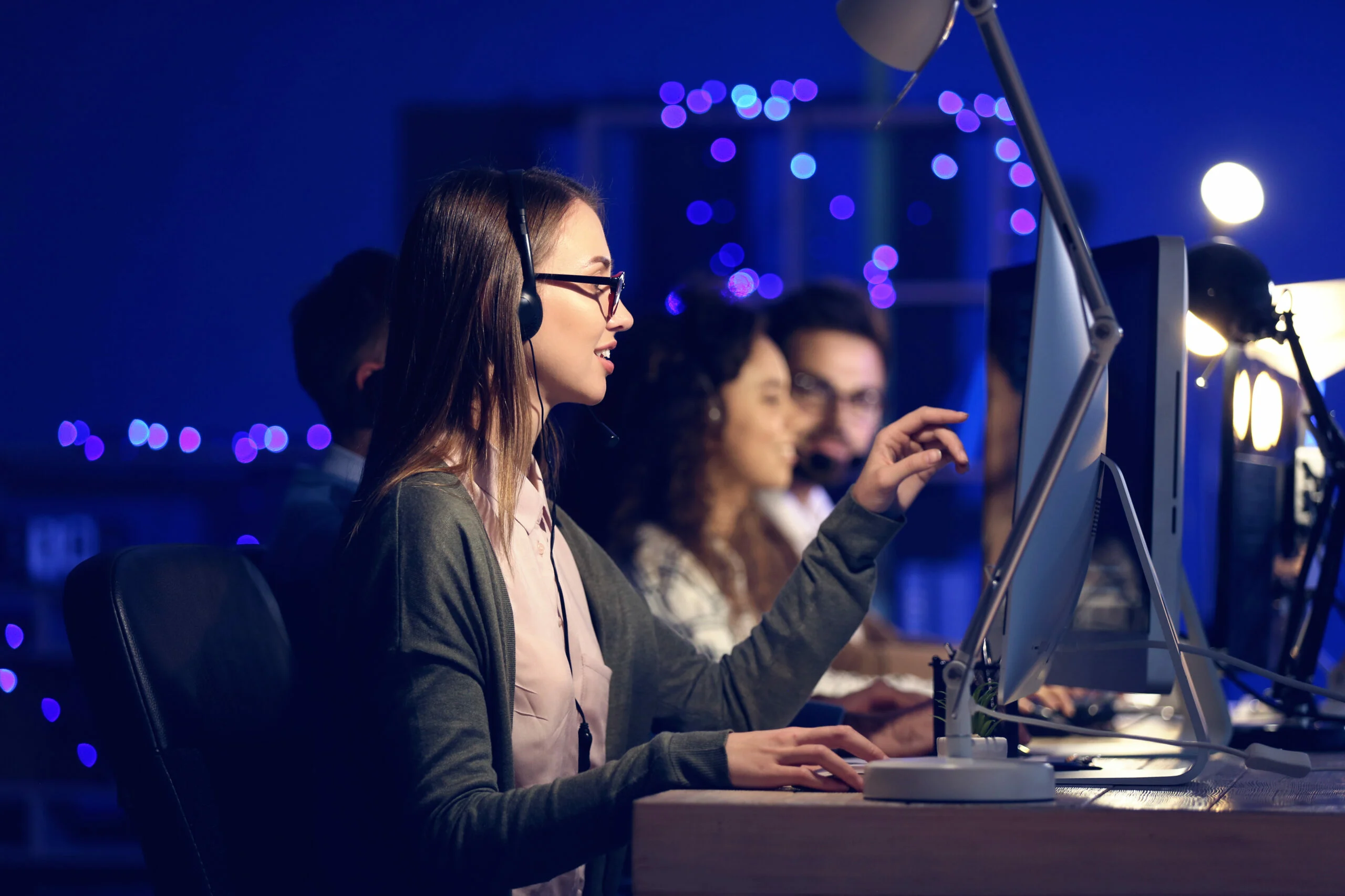 People working at computers in darkness.