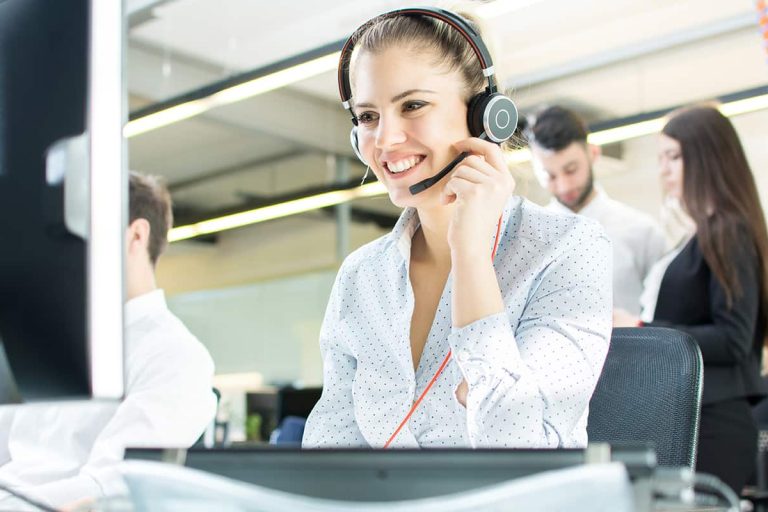 Smiling agent woman with headsets. Portrait of call center worker at office.