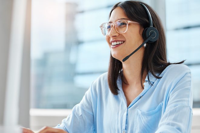 Friendly female customer support agent at a BPO company using a headset, representing the human touch in AI-powered service solutions by cxperts