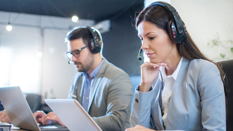 BPO customer service agents working on laptops in a modern call center—illustrating scaling challenges and support solutions