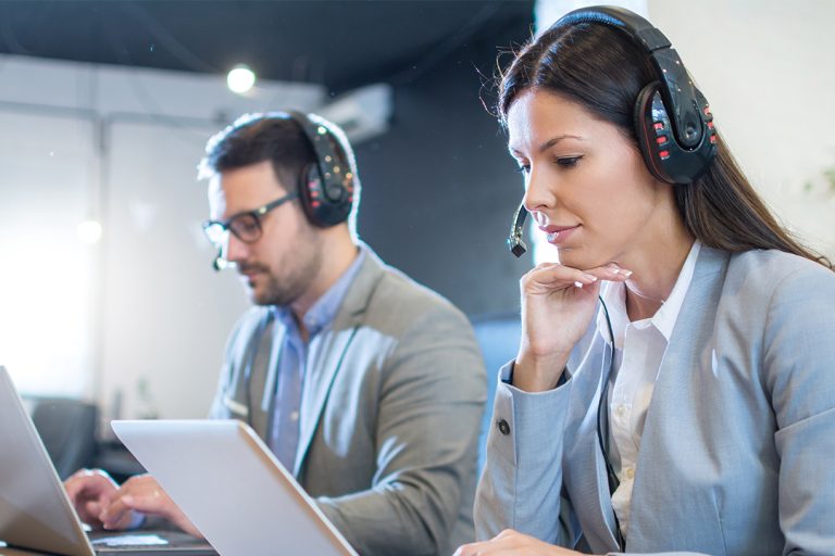 BPO customer service agents working on laptops in a modern call center—illustrating scaling challenges and support solutions