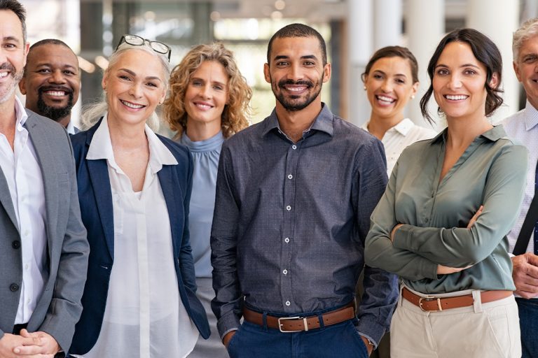 Diverse group of confident business professionals smiling in modern office setting, representing strong BPO-client relationships and rebuilding trust through collaboration.