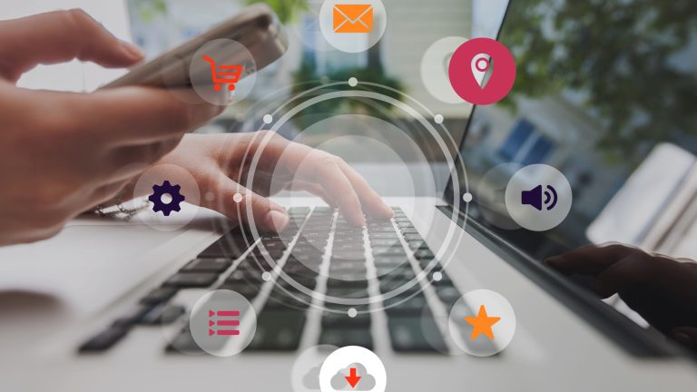 Omnichannel digital marketing concept showing hands using smartphone and laptop with icons for shopping, email, location, settings, media, downloads, and customer engagement